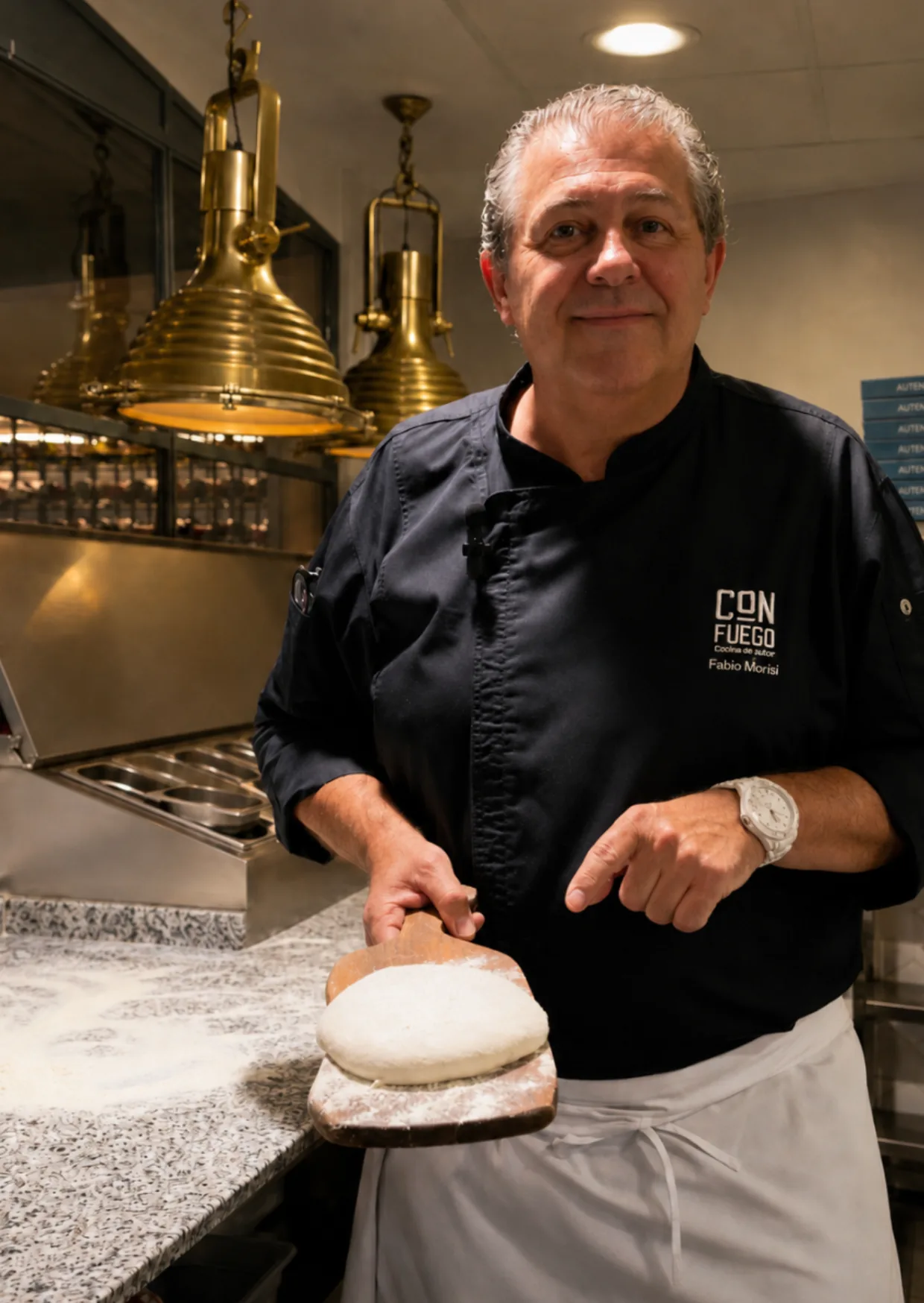 El chef Fabio Morisi sosteniendo la masa de pizza sobre la pala en la cocina de ÔVEN