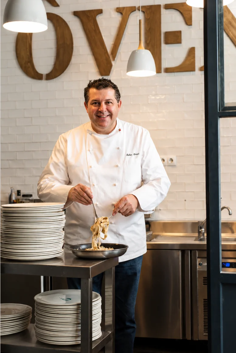 El chef Fabio Morisi emplatando pasta fresca en la cocina del restaurante ÔVEN